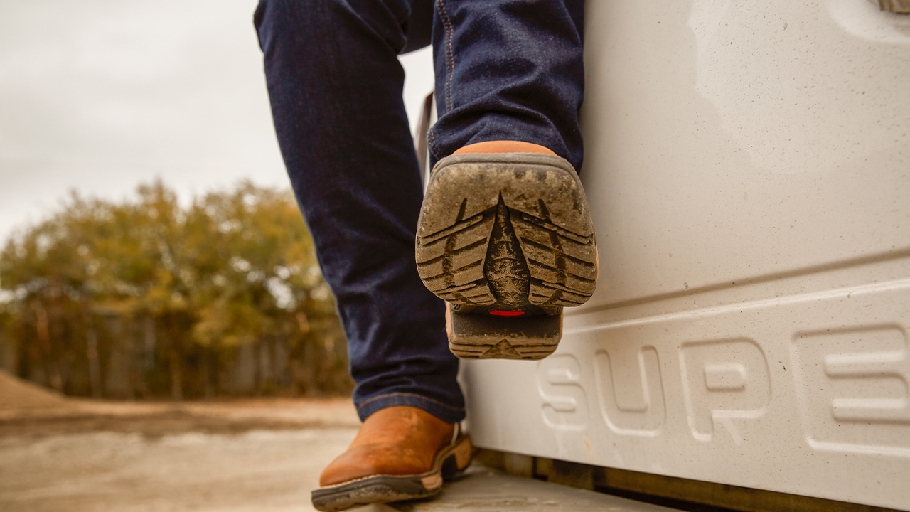 The outsole of the women's Rush boot in Cedar Brown (SE4359) on the back of a truck.